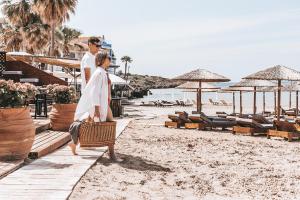 a man and a woman walking on the beach at Almira Hotel in Arkoudi