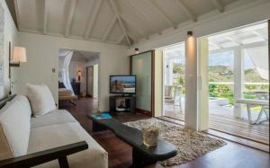 uma sala de estar com um sofá e uma televisão em Saint Barth Villa 10 em Marigot