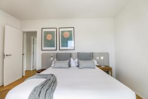 um quarto com uma grande cama branca e 2 almofadas em Agaete 3BR Tropical Views em Agaete