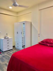 a bedroom with a red bed and a white cabinet at Resting View in Male City