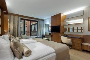 a hotel room with two beds and a desk at Grand Millennium Konya in Konya