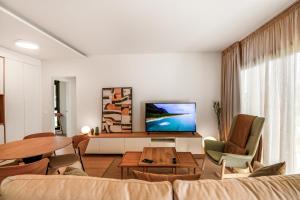 een woonkamer met een bank en een tv bij Agaete 3BR Tropical Views in Agaete