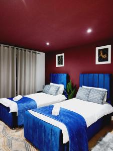 - une chambre avec 2 lits avec des couvertures bleues dans l'établissement Luxury 3 Bed flat close to many attractions, à Londres