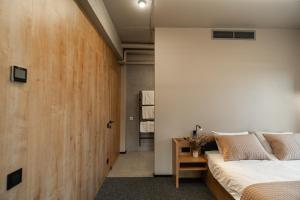 a bedroom with a bed and a wooden wall at Hotel MiraMar smart room in Kovelʼ
