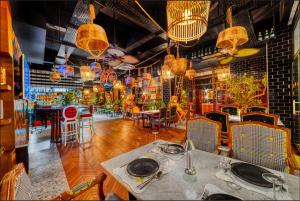 a restaurant with a table and chairs and chandeliers at Anjeliq Downtown Boutique Hotel in Alanya