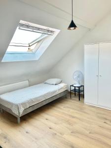 1 dormitorio con cama y ventana en Trietje en Ghent