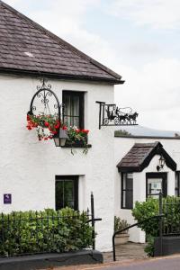a white house with flower boxes on it at The Glenbeigh Hotel in Glenbeigh