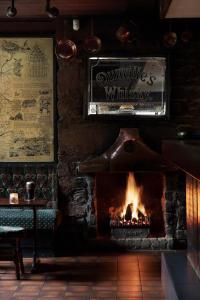 a fireplace in a pub with a sign on the wall at The Glenbeigh Hotel in Glenbeigh