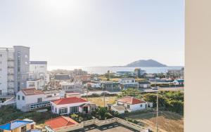 una città con edifici e l'oceano sullo sfondo di Aroomi Hotel Hyupjae a Jeju