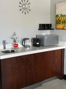a kitchen counter with a sink and a microwave at Blouberg by the Sea in Cape Town