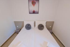 een kamer met een bed met 2 stoelen en een luchtballon bij Double L House in Novalja