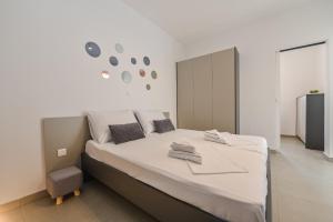 een slaapkamer met een groot bed met witte lakens bij Double L House in Novalja