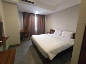 um quarto com uma grande cama branca num quarto em Studio4 in the heart of the city em Denpasar