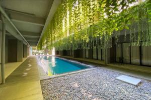 a swimming pool in a building with plants hanging from the ceiling at Studio4 in the heart of the city in Denpasar