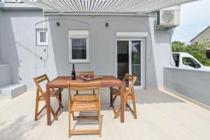 een houten tafel en stoelen op een terras bij Double L House in Novalja +7 foto's
