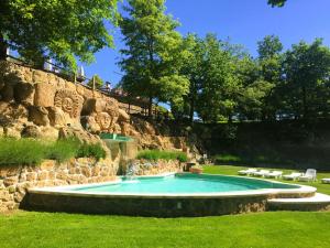 uma piscina num quintal junto a uma parede de pedra em Residence surrounded by greenery with swimming pool in Sorano em Sorano
