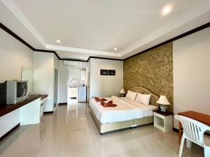 a hotel room with a bed and a television at Tan Residence in Ko Lanta