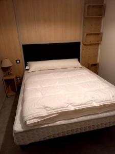 een groot wit bed in een kleine kamer bij Nature Holiday's Domaine L'OREE d'ARZAL in Arzal