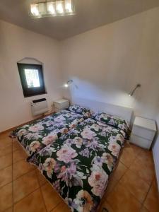 a bed with a floral comforter in a bedroom at Lorica Apartment Residence LagoSila in Lorica