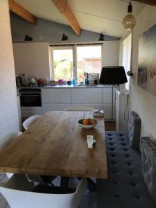 cocina con mesa de madera con sillas y comedor en Rekerlanden 211, en Warmenhuizen