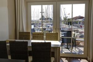 comedor con mesa y sillas y puerto deportivo en HafenResidenz Fehmarn, en Lemkenhafen auf Fehmarn