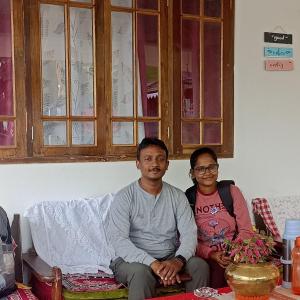 um homem e uma mulher sentados num sofá em Valley View Homestay em Darjeeling