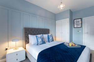 een slaapkamer met een groot bed en een blauwe deken bij Elliot Oliver - Luxurious Two Bedroom Apartment in The Docks in Gloucester