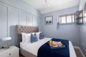 a bedroom with a bed with a tray of food on it at Elliot Oliver - Luxurious Two Bedroom Apartment in The Docks in Gloucester