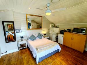a bedroom with a large bed and a kitchen at Swiss Cottage Guest House in Cape Town