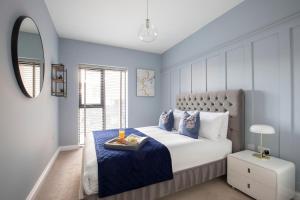 a blue bedroom with a bed with a tray on it at Elliot Oliver - Luxurious Two Bedroom Apartment in The Docks in Gloucester