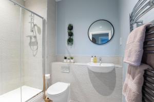 een badkamer met een toilet, een wastafel en een spiegel bij Elliot Oliver - Luxurious Two Bedroom Apartment in The Docks in Gloucester