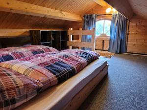ein Schlafzimmer mit einem Bett in einem Blockhaus in der Unterkunft Christinas Ferienhäuser in Rodewald in Neudorf