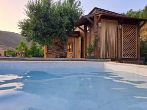 a house with a swimming pool in front of a house at Wooden House at the Mountain-private in Paránimfoi
