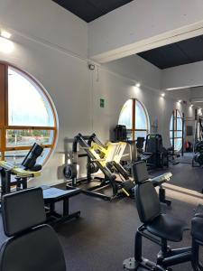 a gym with treadmills and ellipticals in a room at Villa Greif in Lignano Sabbiadoro