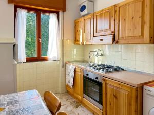 cocina con armarios de madera y horno con fogones en Bellavista - Residence in Barzio center near free ski shuttle, en Barzio