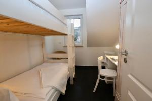 a small room with a bunk bed and a desk at Ferienwohnung4 im Haus Möwe in Thiessow
