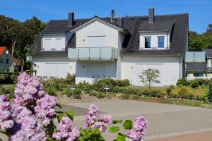 una casa con fiori rosa di fronte di Ferienwohnung4 im Haus Möwe a Thiessow