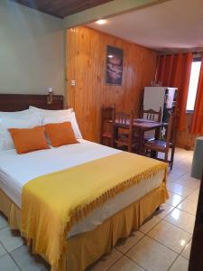 Un dormitorio con una cama con una manta amarilla. en Posada Portal del Iguazu en Puerto Iguazú