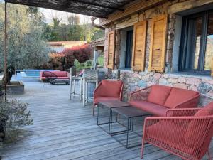 un patio avec des chaises et des tables rouges dans un bâtiment dans l'établissement Casa Santa Lucia, à Bocognano