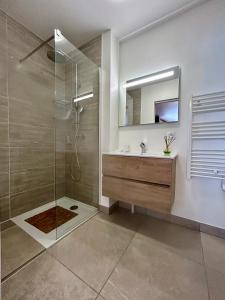 a bathroom with a shower and a sink and a mirror at Appartement Valmeinier centre - Le Céleste in Valmeinier