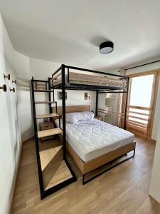 a bedroom with a bunk bed with a ladder at Appartement Valmeinier centre - Le Céleste in Valmeinier