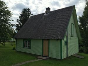 una casa verde con tetto nero di Paju Holiday Home a Otepää
