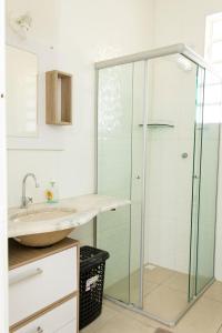 een badkamer met een glazen douche en een wastafel bij Apto com Wi Fi no centro de Belo Horizonte MG in Belo Horizonte
