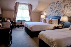 a hotel room with two beds and a window at The Abbeyleix Manor Hotel in Abbeyleix
