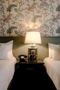 a lamp sitting on a table between two beds at The Abbeyleix Manor Hotel in Abbeyleix