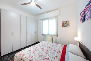 a white bedroom with a bed and a window at Il Corallo in Albisola Superiore