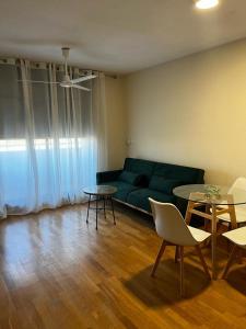 una sala de estar con un sofá verde y mesas. en Apartamento Arcos Costa Cálida III, en Águilas