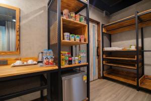 um quarto com um frigorífico, uma mesa e prateleiras em The Loft Bar365 em Buri Ram