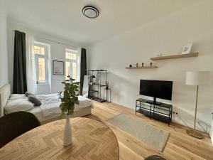 a living room with a bed and a table with a television at FeelHome-Margareten-2 Gäste-WiFi-SmartTV in Vienna