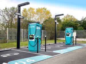 two blue gas pumps in a parking lot at Novotel Toulouse Purpan Aéroport in Toulouse